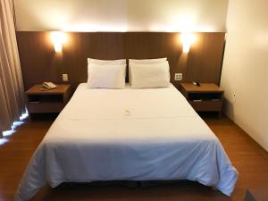塞蒂拉瓜斯塞蒂拉瓜斯公寓式酒店的卧室配有一张带两张桌子的大型白色床
