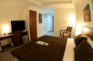 瓜亚基尔HM国际大酒店的配有一张床和一台平面电视的酒店客房