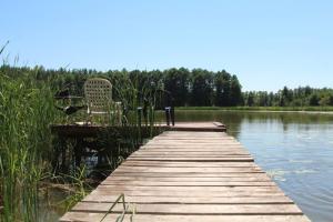 巴尔切沃Domek Zalesie的湖畔木头甲板,带椅子