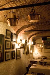安杰拉卢康达拉卡西达酒店的一间用餐室,配有两张桌子和墙上的照片