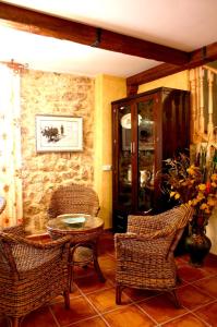 布尔戈斯Casa Rural Valle Esgueva的客房设有藤椅和桌子