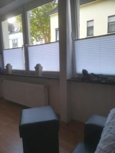 费尔贝特Zentral gelegene Wohnung in Velbert-Mitte的客厅设有2扇窗户和2把凳子