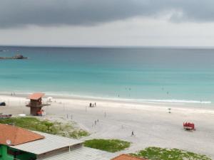 阿拉亚尔-杜卡布Recanto do Pôr do Sol的和水中的人一起欣赏海滩的景色