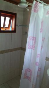 阿布拉奥Hospedagem capitão Hula的带淋浴帘和窗户的浴室