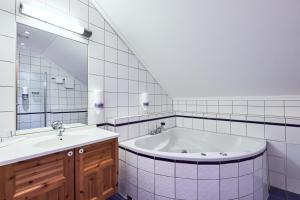 加勒穆恩Garder Hotell og Konferansesenter的带浴缸、水槽和镜子的浴室