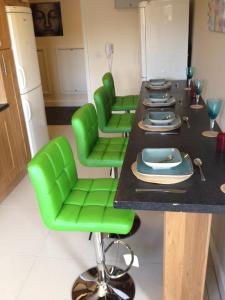 布雷得佛Trigg Hall的一间配备有绿色椅子和桌子的用餐室