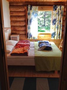 穆奥尼奥Olosloisto Lomat的小木屋内的一张床位,设有窗户
