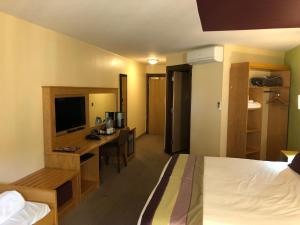 沃灵顿格列佛酒店的酒店客房配有一张床和一张书桌及一台电视