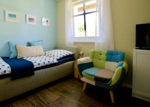 博恩Haus Meerblau的卧室配有床、椅子和窗户。
