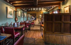 Horndon on the HillThe Bell Inn Hotel的餐厅内带桌椅的用餐室