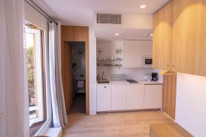 马德里Plaza Mayor Suites & Apartments的一间厨房,配有白色的橱柜和大窗户