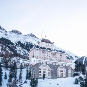 蓬特雷西纳Schloss Hotel & Spa Pontresina的山前大雪中的一座大建筑
