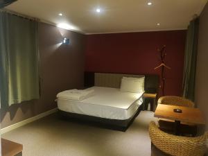 釜山阳光汽车旅馆的一间小卧室,配有一张床和一把椅子