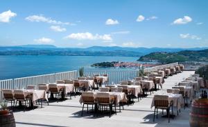 伊佐拉丽城度假酒店的水边阳台的一排桌椅