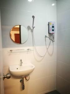 清迈Duangdren Apartment的带淋浴、盥洗盆和镜子的浴室