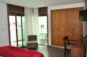 达赫拉Dakhla Sur Mer Hôtel的一间卧室配有一张床,另一间设有阳台。