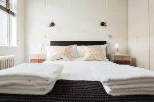 伦敦The Oxford Street Studio - 1BDR in Paddington的卧室配有一张带白色床单和枕头的大床。