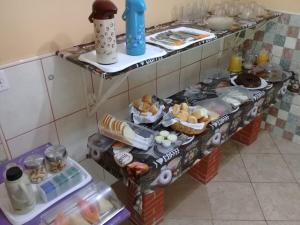 马卡埃Pousada Alto Riviera的厨房里有两个架子,上面装满了不同种类的食物