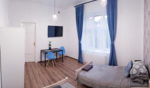 凯尔采Guest Room RÓWNA的一间卧室配有一张床、一张桌子和蓝色的椅子