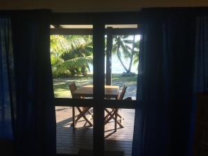 拉罗汤加Shoreline Escape Rarotonga的门上配有桌椅的景色