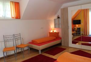 韦尔特湖畔克伦彭多夫Ferienwohnung am Wörthersee Villa Waldbach的客房配有带橙色枕头的床。