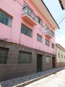 库斯科Tinki Hostel的街道边的粉红色建筑
