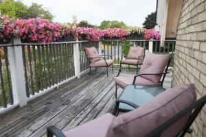 斯特拉福德Avery House B&B的排椅子坐在开满粉红色花的甲板上