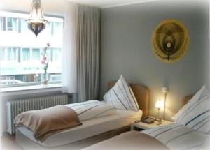 杜塞尔多夫斯缇米尼斯酒店的一间白色卧室,配有两张床和窗户