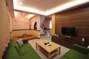 小琉球岛四季轩民宿的客厅配有绿色沙发和电视