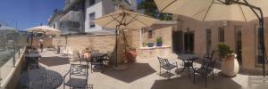 海法罗梅马马罗姆公寓的庭院配有桌椅和遮阳伞。