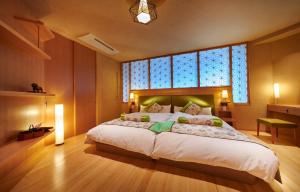 高山本阵平野屋花兆庵酒店的一间卧室设有一张大床和大窗户