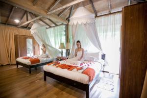 峇六拜Fig Tree Hills Resort (花果山度假村)的女人坐在卧室的床上