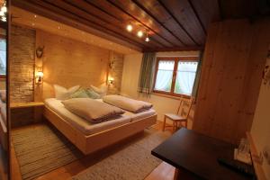 瓦尔德阿尔贝格Hotel Maroi的木制客房内的一间卧室,配有一张床