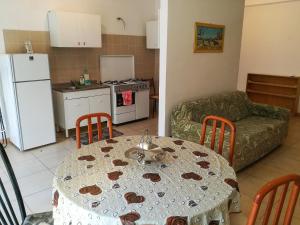 维拉皮亚纳Appartamento a Villapiana Lido的厨房以及带桌子和沙发的客厅。