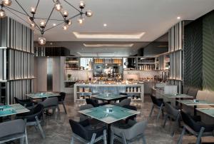 雅加达雅加达塞蒂亚布迪辉盛坊国际公寓的一间带桌椅的餐厅和一间酒吧