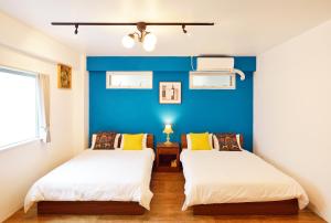 宜野湾市Douce的蓝色墙壁客房的两张床