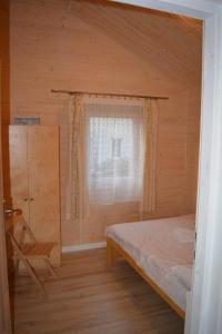 ZełwągiRÓŻANY ZAKĄTEK的一间卧室设有一张床、一个窗口和一把椅子