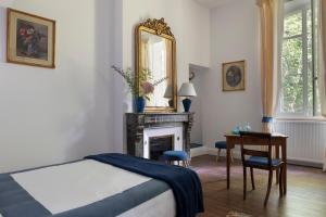 Pessac-sur-DordogneChâteau Le Méjean的一间卧室配有一张床、镜子和一张桌子