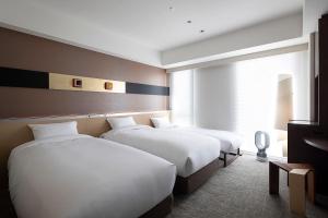 京都京都克劳斯酒店的酒店客房设有两张床和窗户。