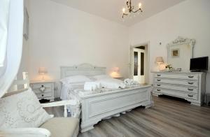 克利通诺河畔坎佩洛Shabby House Nonna Peppa的一间白色卧室,配有床和2个梳妆台