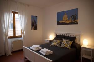 罗马Vista Cupola House的一间卧室配有一张带两盏灯的床和一扇窗户。