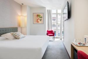 桑坦德阿巴桑坦德酒店的卧室配有白色的床和红色椅子