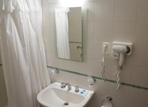 拉巴斯Hotel Milton的一间带水槽、镜子和淋浴的浴室