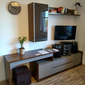 斯武普斯克Apartamenty Słupsk的客房设有一张桌子、一台电视和一台电视