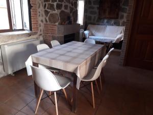 阿维拉Casa Luz的一间带桌子和白色椅子的用餐室