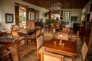 蒙特内哥罗Hotel Delirio Campestre的用餐室配有木桌和椅子