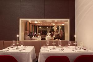 阿德尔博登Bellevue Parkhotel & Spa - Relais & Châteaux的用餐室设有2张桌子和酒杯
