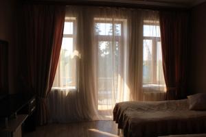 İvanovkaIvanovka Guest House的一间卧室设有一张床和两个大窗户