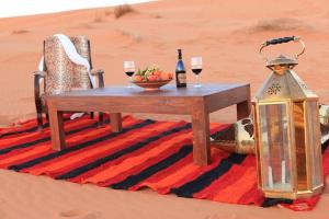 扎古拉Karim Sahara Prestige的沙漠中的一张桌子,放上两杯葡萄酒