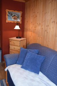 MörtschachFerienwohnung Suntinger的一间卧室配有一张带蓝色枕头和一盏灯的床。
